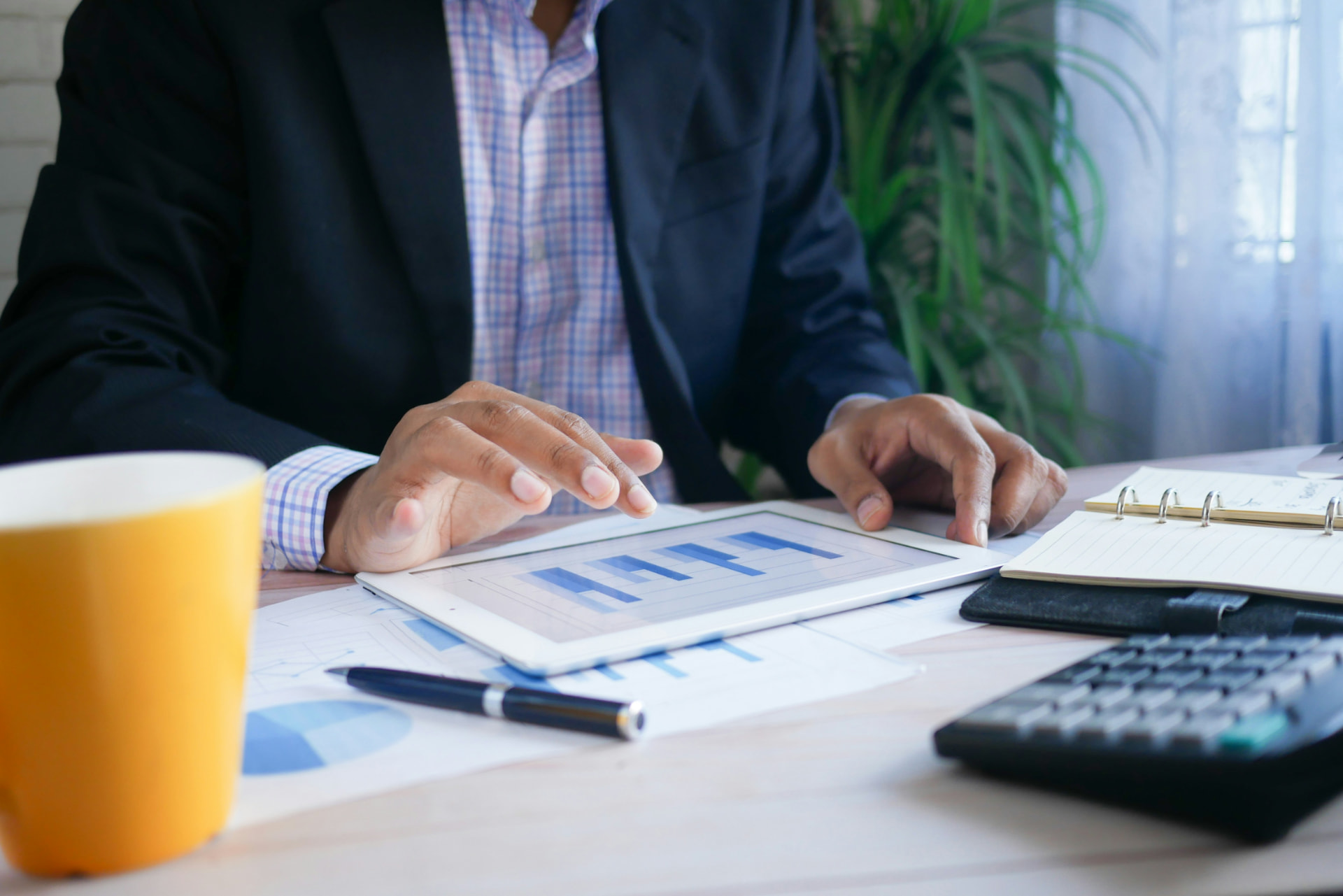 Calculator, pen and financial charts on a desk